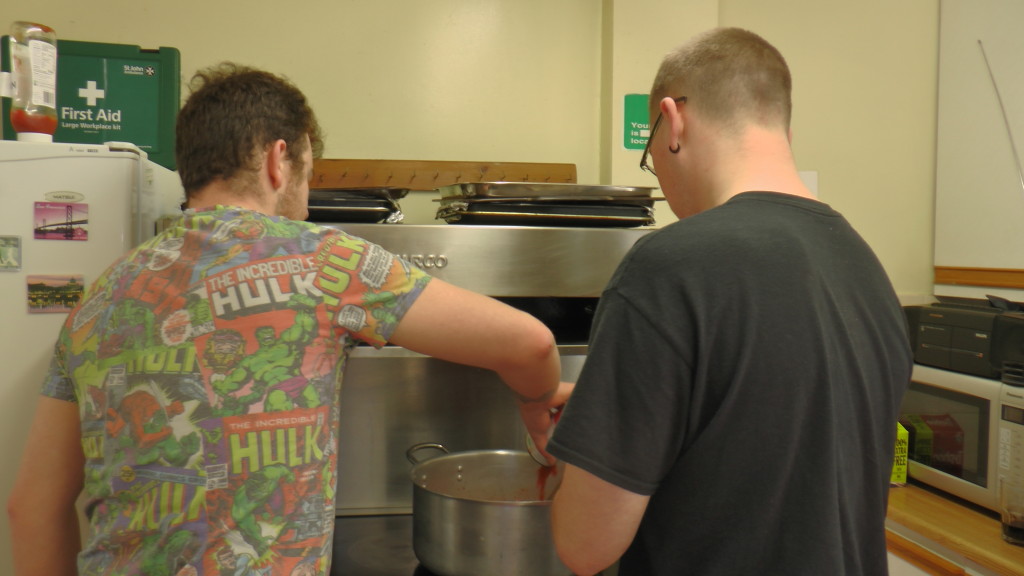 A customer and a volunteer work together to make lunch for all.